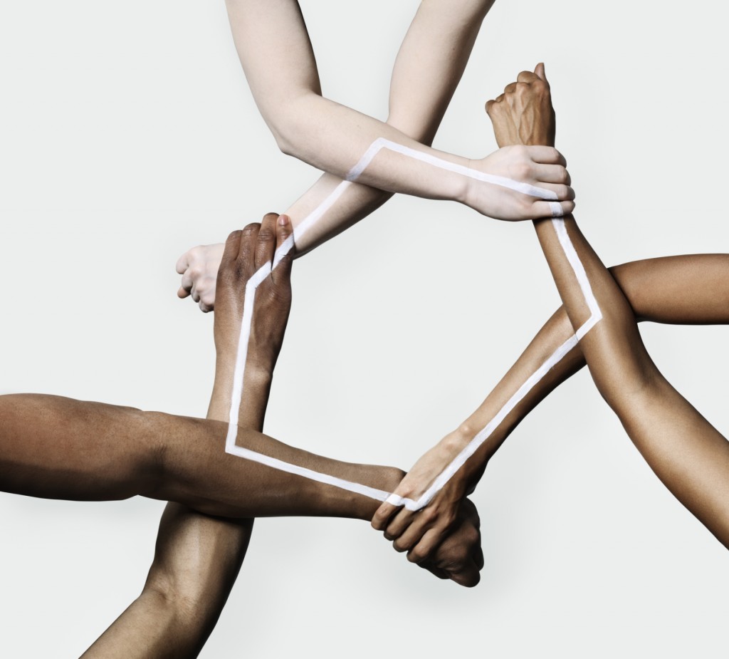 Three peoples hands and arms forming a triangle
